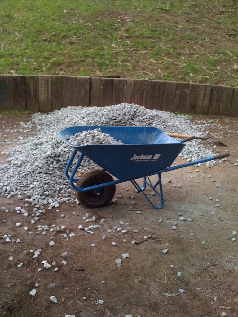 Drainage rock is carried up the trail by wheelbarrow.