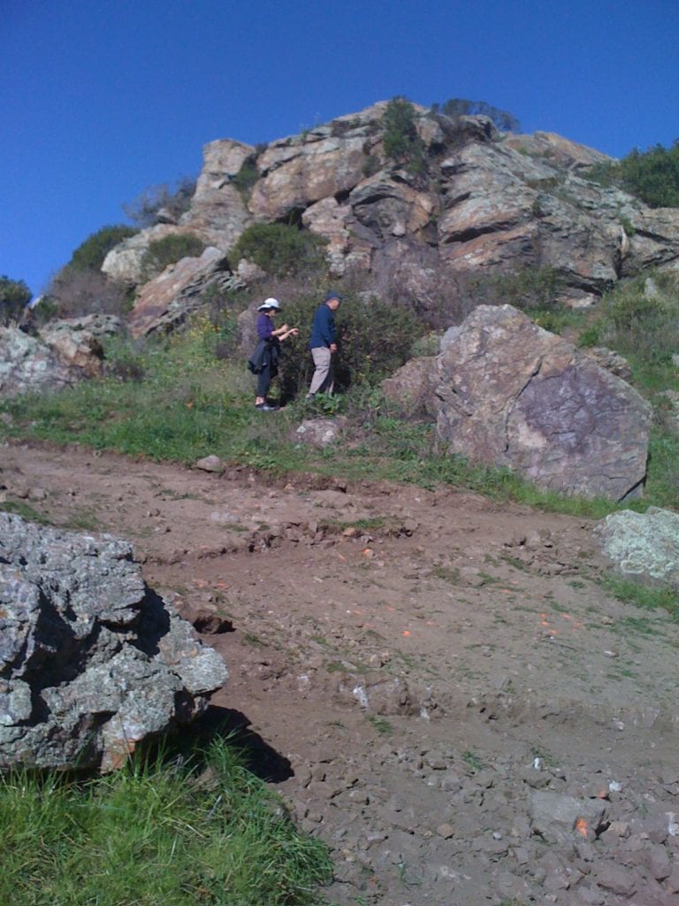 Two walkers hiking through "saddle" on new Saddle Trail. January 30.