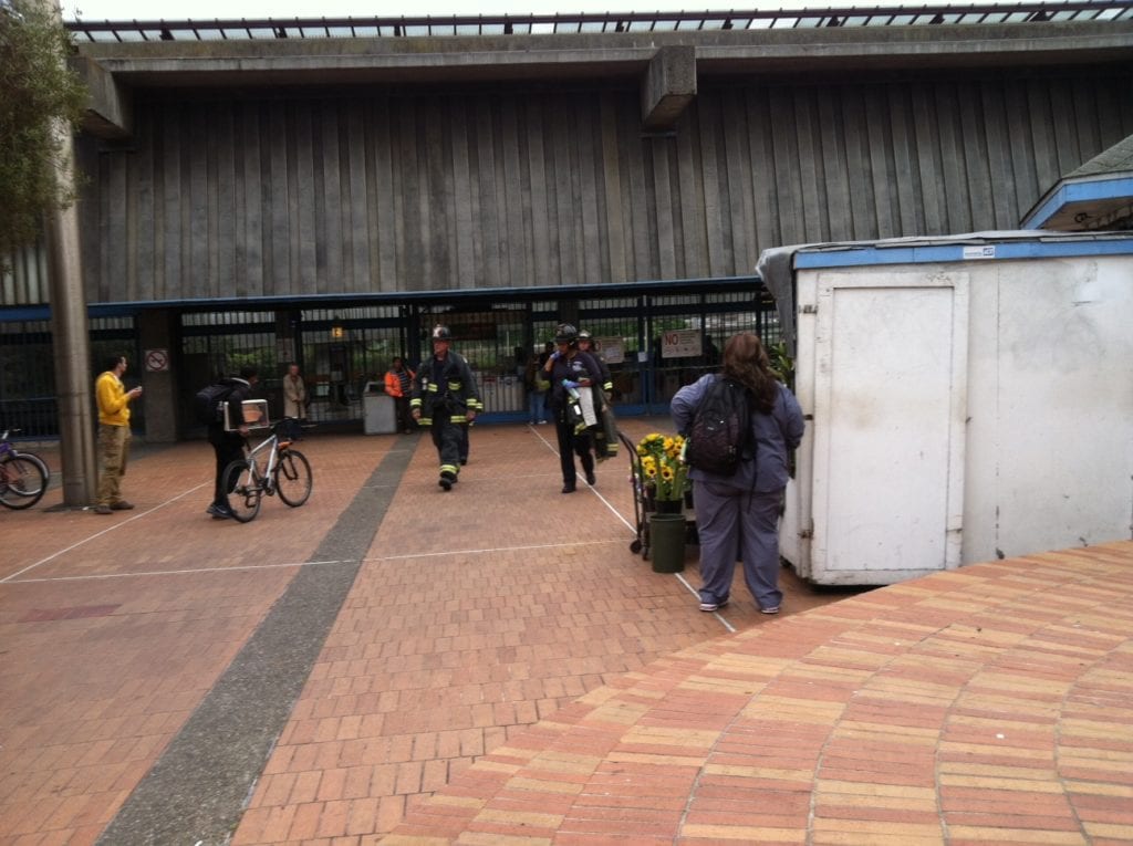 Would-be BART passengers confer at the Glen Park BART plaza as they wait to hear when the trains will begin running again. Photo by Carolyn Deacy.