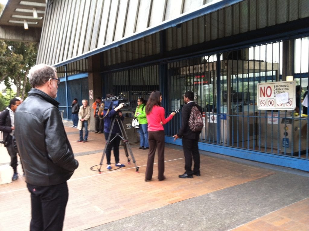 Reporters interviewing people at Glen Park BART. Photo by Carolyn Deacy.