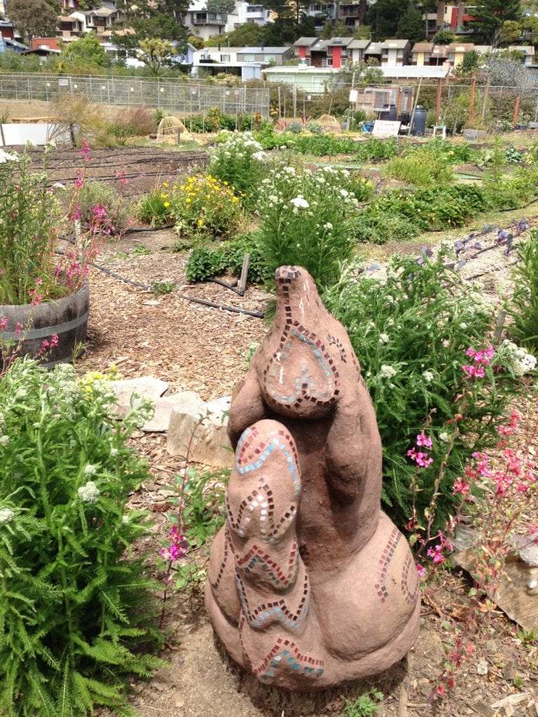 ECOSF's Tori Jacobs is a sculptor. This rendition of a Glen Canyon coyote graces the student garden at the Academy of Arts and Sciences student farm.