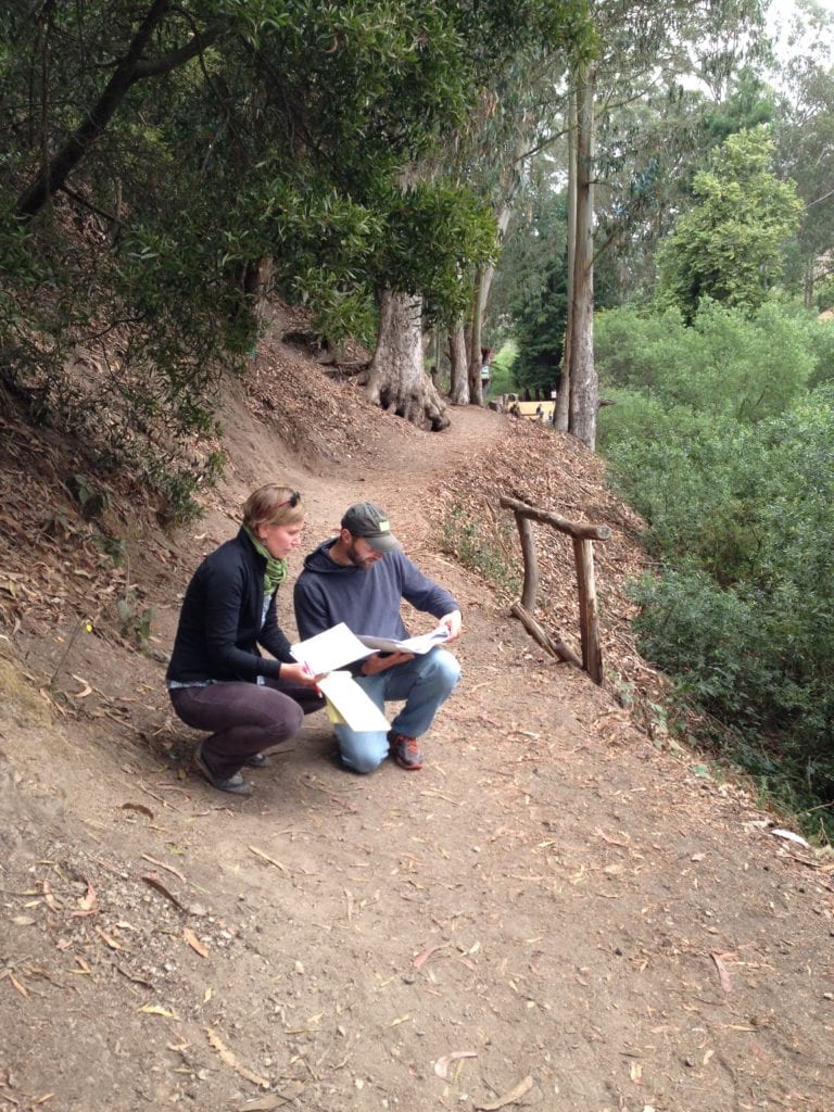 Melinda Stockmann and Joe Grey studying trail logs and maps on Banana Slug Way in early August. The railing to Grey's left will be replaced by a sutter wall. 