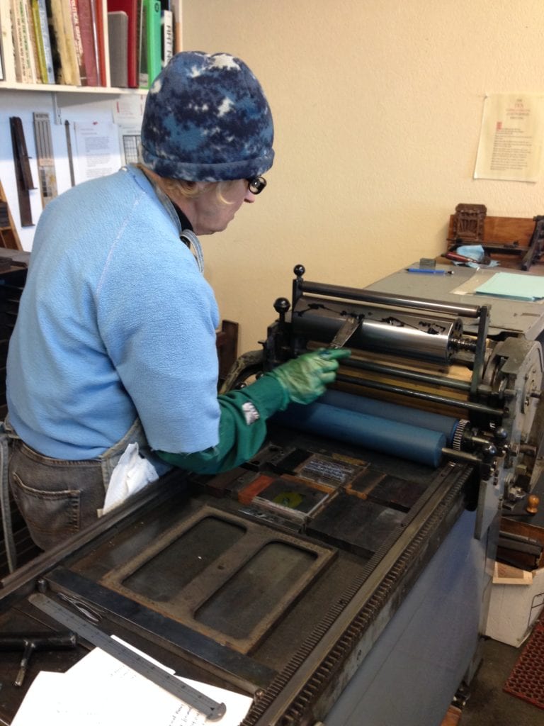 Mary inspecting rollers after they have been inked.