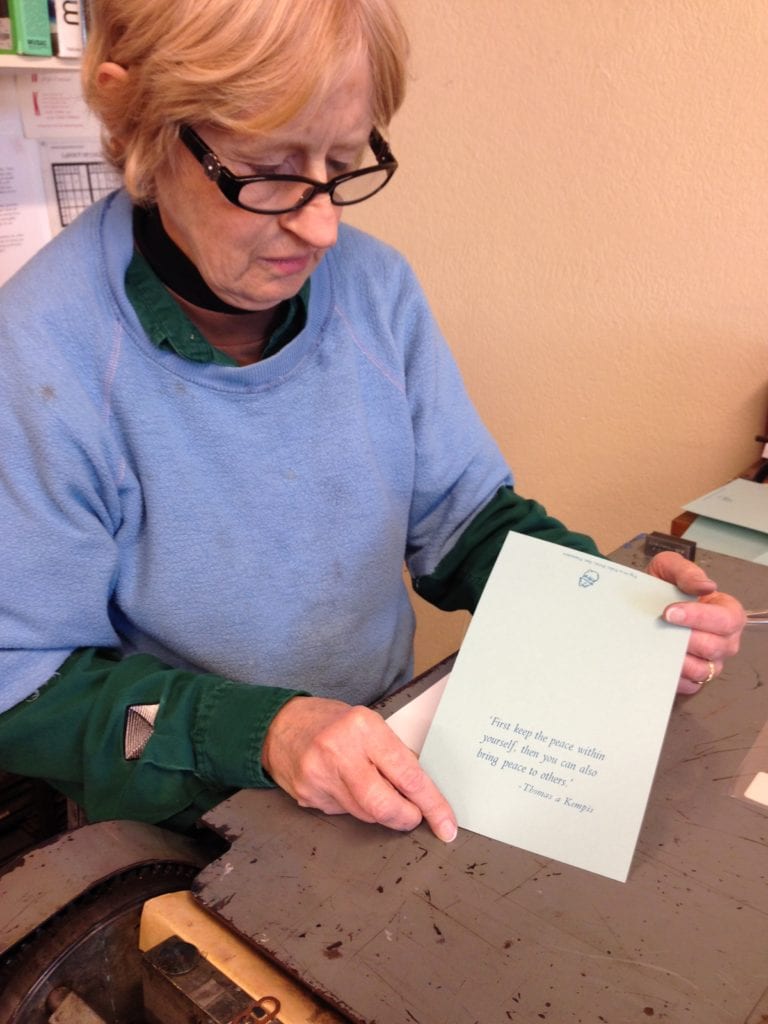 Mary studying her Christmas card, one of 40 she printed on December 13. 