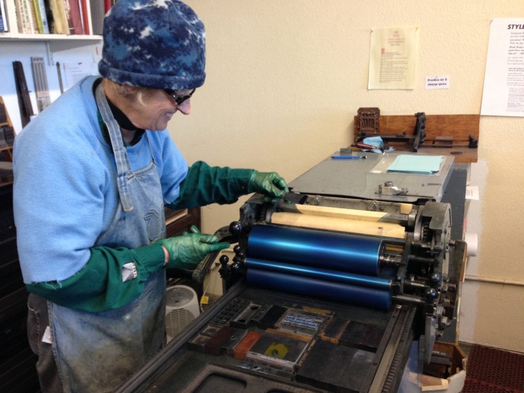 Mary inking letterpress printer roller. 