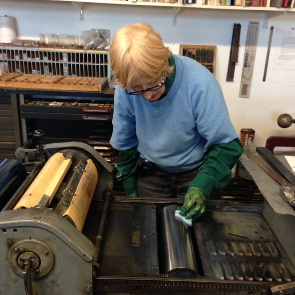 Mary cleaning the roller, after her printing is completed.