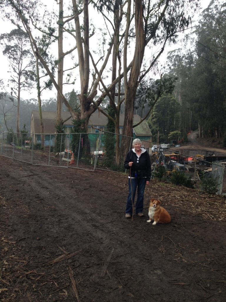 Joost Street resident, and Glen Canyon dog walker Kathleen Kelley pictured with Luna in front of two coastal redwood trees.