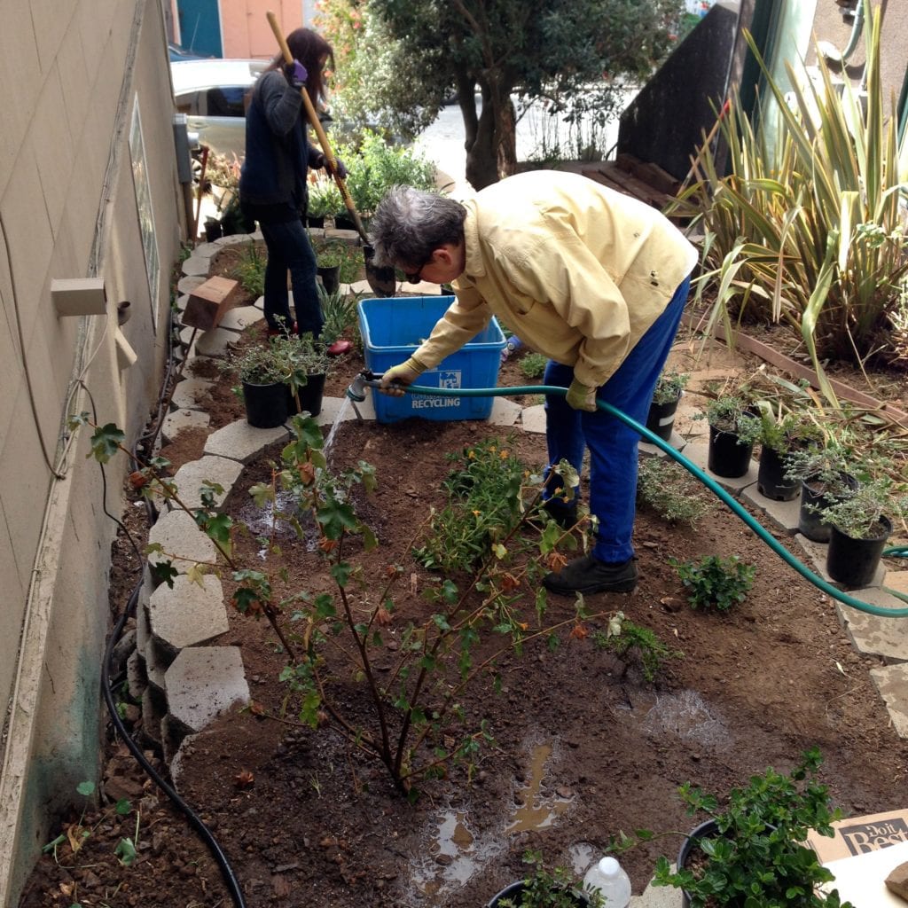 Ananda White, who's in the second grade, lifts bark, making his contribution to the the Surrey Street work party.