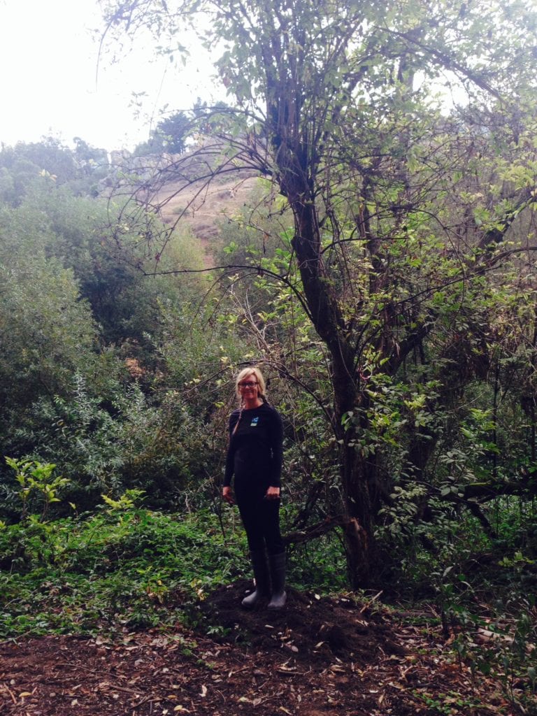 Jenny Sotelo standing by a blue elderberry tree on west side of Islais Creek.