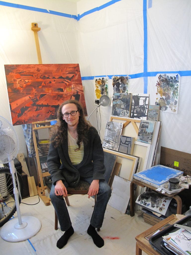 - Robbie Sugg sitting in his San Jose studio. Photo by John Landry