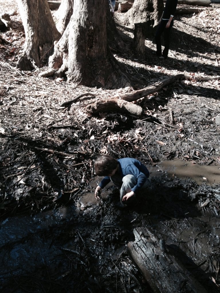 A Brightworks School student checking out an earthworm in Islais Creek.