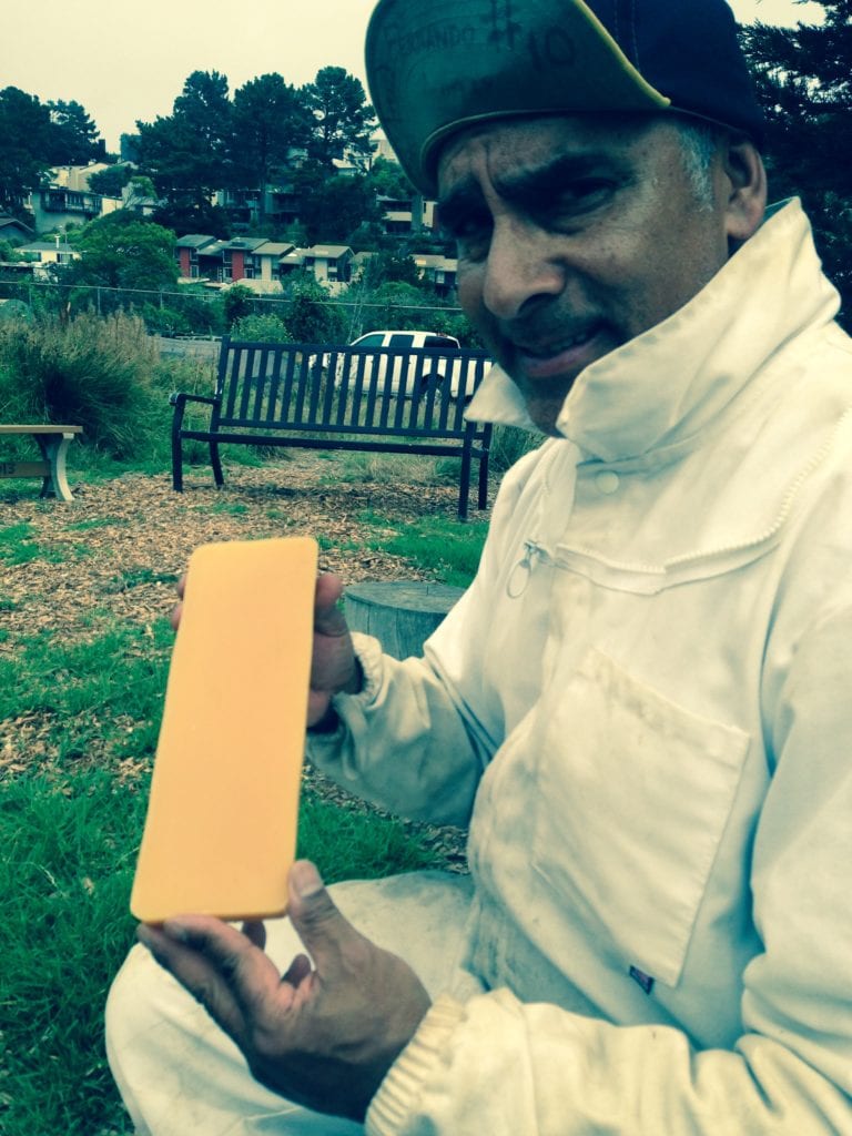 Fernando Aguilar holding a honey comb from his two beehives, used to make ECOSF hand balm.